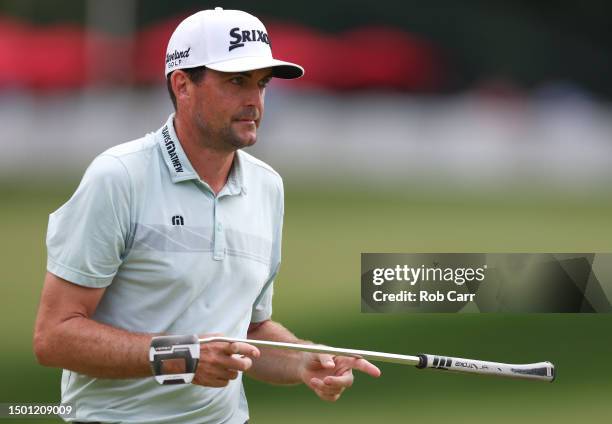 Keegan Bradley of the United States hands his putter to caddie after making a putt on the ninth green during the third round of the Travelers...