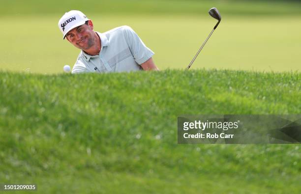Keegan Bradley of the United States plays a shot from a bunker on the ninth hole during the third round of the Travelers Championship at TPC River...