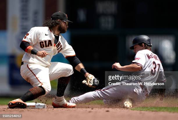 Jake McCarthy of the Arizona Diamondbacks slides to steal second base ahead of the tag from Brandon Crawford of the San Francisco Giants in the top...