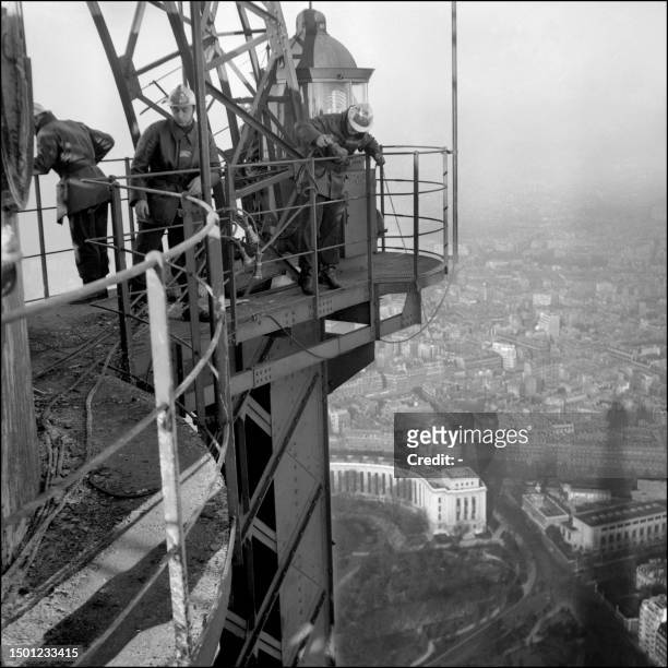Des pompiers sont à l'oeuvre, le 3 janvier 1956, sur la dernière plateforme de la Tour Effeil où un incendie a éclaté détruisant en partie les...