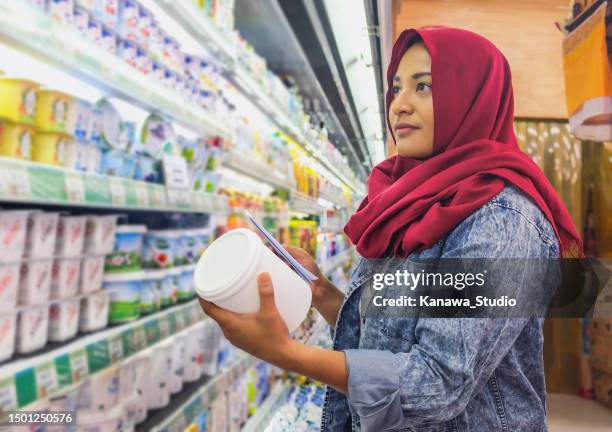 malaysische muslimische frau kauft joghurt im supermarkt - chubby man shopping stock-fotos und bilder