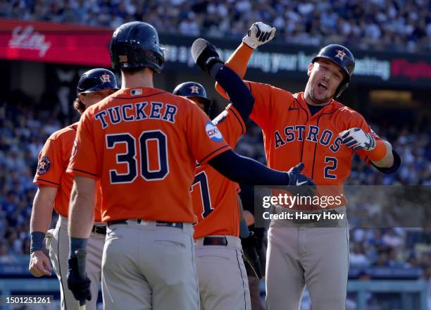 Alex Bregman of the Houston Astros celebrates his grand slam homerun with Jose Altuve and Kyle Tucker, to take a 5-3 lead over the Los Angeles...