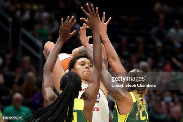 Brittney Griner of the Phoenix Mercury looks to pass against Ezi Magbegor and Mercedes Russell of the Seattle Storm during the first quarter at...
