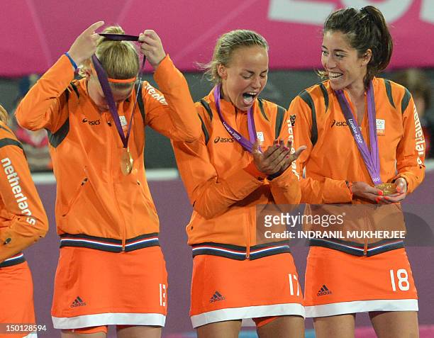 Netherlands Maartje Paumen and teammates Netherlands Naomi van As and Caia van Maasakker show their delight while holding their gold medals as they...