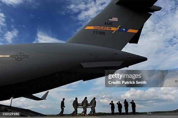 Army soldiers carry the flag-draped transfer case containing the remains of U.S. Army Maj. Thomas E. Kennedy, during a dignified transfer at Dover...