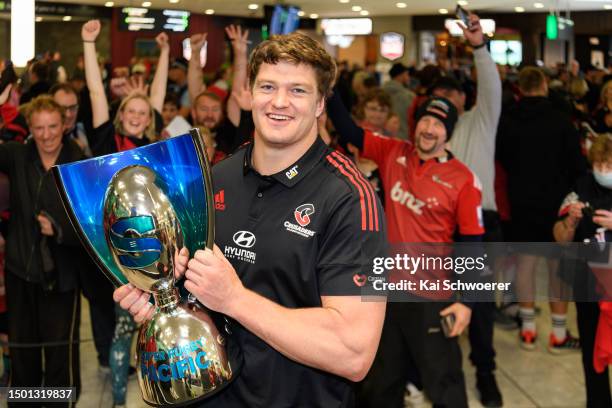 Captain Scott Barrett lifts the Super Rugby trophy during the Crusaders arrival at Christchurch Airport on June 25, 2023 in Christchurch, New...