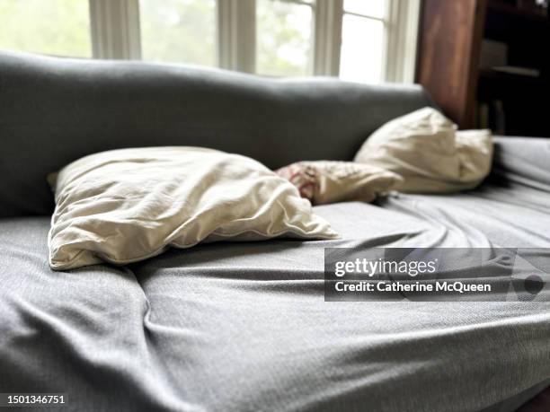 couch surfing: sofa covered in slipcover - sofa bed stock pictures, royalty-free photos & images