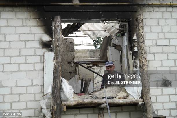 Local resident Mikhail looks out from his house destroyed by Ukrainian strikes in the village of Novaya Tavolzhanka, near the border with Ukraine in...