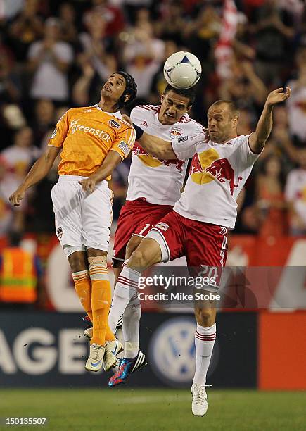 Tim Cahill of the New York Red Bulls heads the ball in front of teammate Joel Lindpere and Calen Carr of the Houston Dynamo at Red Bull Arena on...