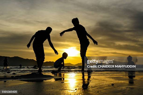 People play on a beach at sunset in Banda Aceh on July 4, 2023.