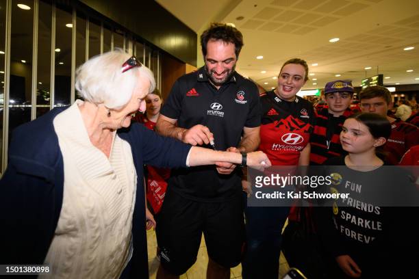 Sam Whitelock signs the arm of a fan during the Crusaders arrival at Christchurch Airport on June 25, 2023 in Christchurch, New Zealand. The...