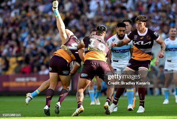 Jaimin Jolliffe of the Titans is picked up in the tackle by Billy Walters of the Broncos during the round 17 NRL match between Brisbane Broncos and...