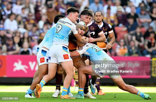 Jordan Riki of the Broncos is tackled during the round 17 NRL match between Brisbane Broncos and Gold Coast Titans at Suncorp Stadium on June 25,...