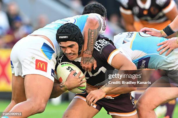 Brendan Piakura of the Broncos is tackled during the round 17 NRL match between Brisbane Broncos and Gold Coast Titans at Suncorp Stadium on June 25,...