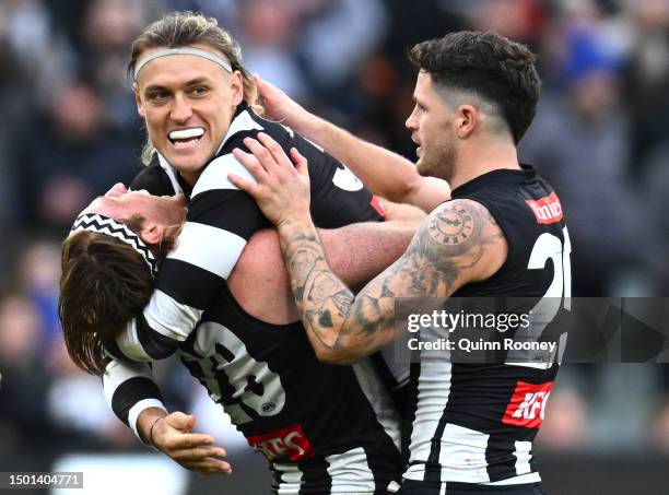 Darcy Moore, Nathan Murphy and Jack Crisp of the Magpies celebrate winning the round 15 AFL match between Collingwood Magpies and Adelaide Crows at...