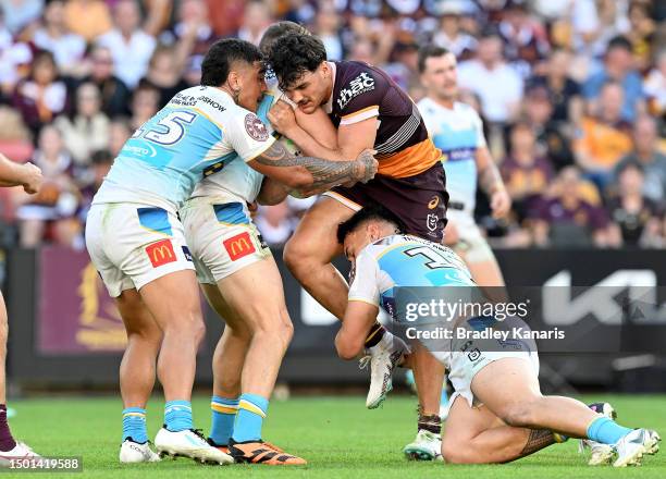 Herbie Farnworth of the Broncos is tackled during the round 17 NRL match between Brisbane Broncos and Gold Coast Titans at Suncorp Stadium on June...
