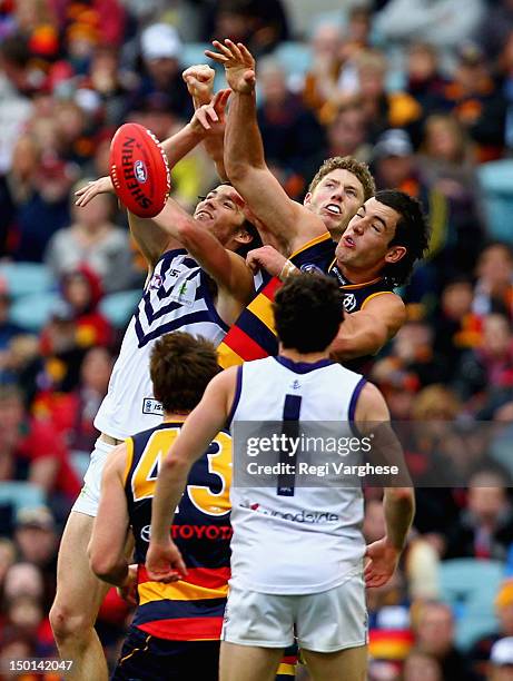 Taylor Walker of the Crows contest a mark with Dylan Robertson and Zac Dawson of the Dockers during the round 20 AFL match between the Adelaide Crows...