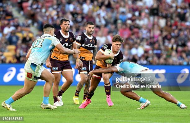 Reece Walsh of the Broncos takes on the defence during the round 17 NRL match between Brisbane Broncos and Gold Coast Titans at Suncorp Stadium on...