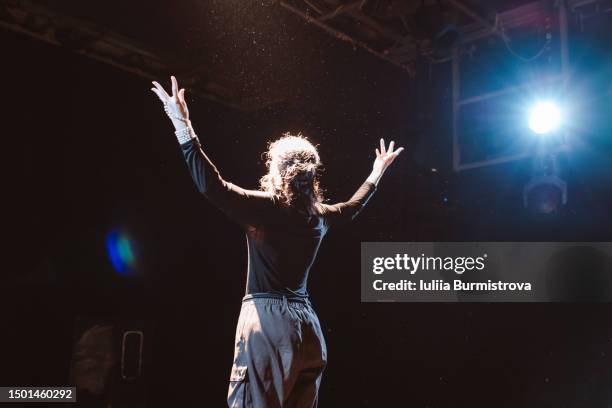 captivating female performer standing on stage in student theater club during emotional recital - industria teatral fotografías e imágenes de stock