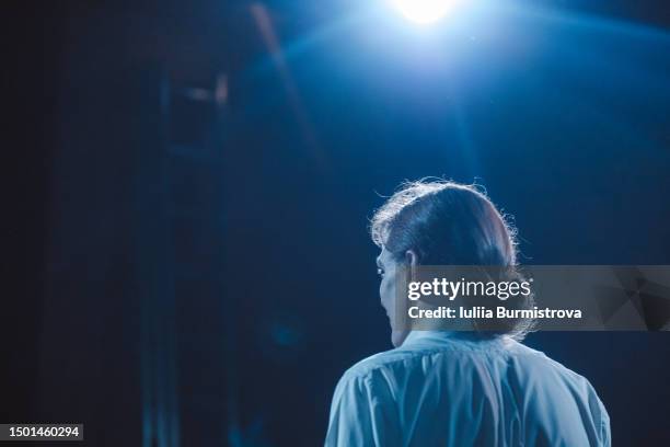 rear view of young actor reciting powerful monologue on stage of student drama club - monoloog fotografías e imágenes de stock