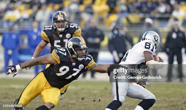 Linebacker Kendrell Bell of the Pittsburgh Steelers reaches to tackle wide receiver Tim Brown of the Oakland Raiders during a game at Heinz Field on...