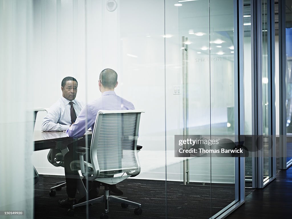Two businessmen in discussion in conference room