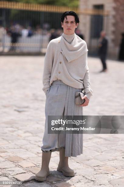 Chase Hudson is seen wearing a beige sweater jacket, grey suit pants and beige rubber boots outside Dior Homme during the Menswear Spring/Summer 2024...