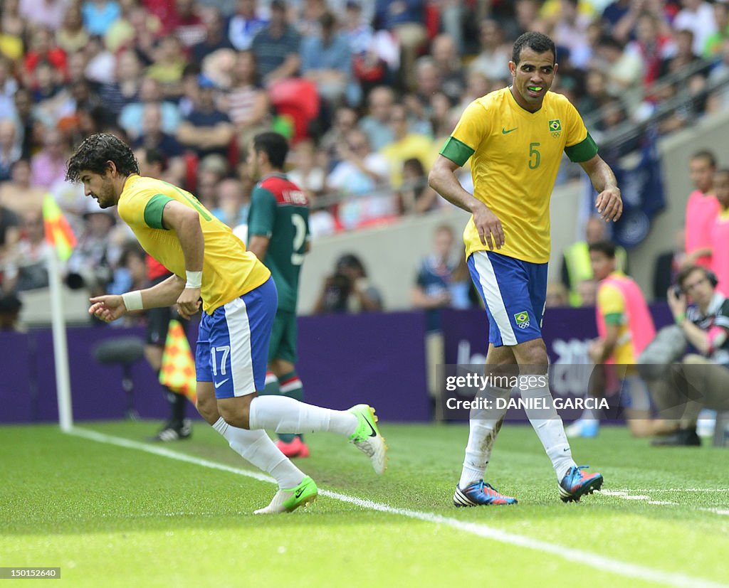 Brazil's midfielder Sandro (R) leaves th