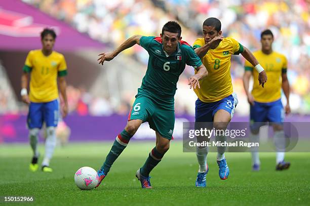 Hector Herrera of Mexico battles for the ball with Romulo of Brazil during the Men's Football Final between Brazil and Mexico on Day 15 of the London...