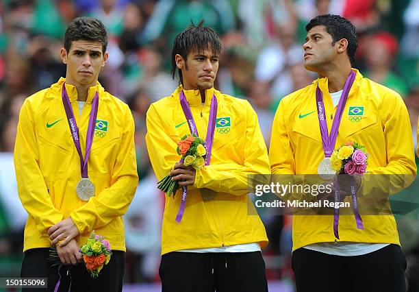 Oscar of Brazil, Neymar of Brazil and Hulk of Brazil look on with their silver medals during the medal ceremony for the Men's Football Final between...