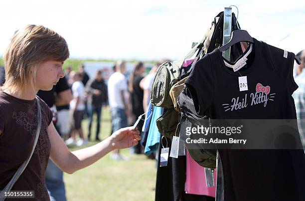 Participant browses a rack of t-shirts for sale including one modeled after Hello Kitty products reading "Heil Kitty," for sale at the German...