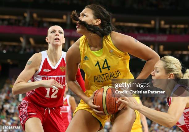 Liz Cambage of Australia attempts a shot in the first half against Irina Osipova and Nadezhda Grishaeva of Russia during the Women's Basketball...