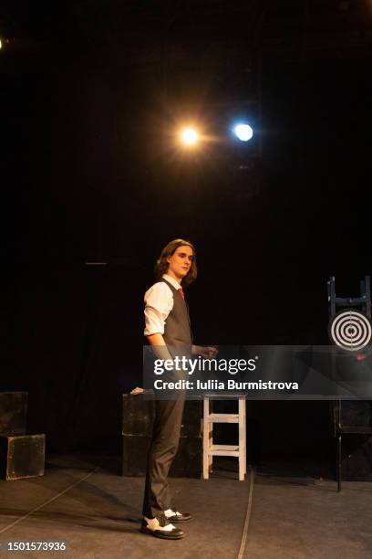 side view of good-looking young man in vintage suit with vest standing on stage of amateur theater - schauspieler stock-fotos und bilder