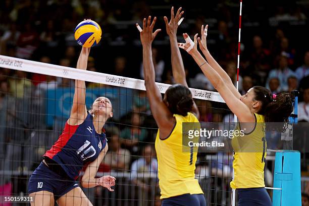 Jordan Larson of United States goes up for the spike against Fabiana Claudino and Sheilla Castro of Brazil during the Women's Volleyball gold medal...