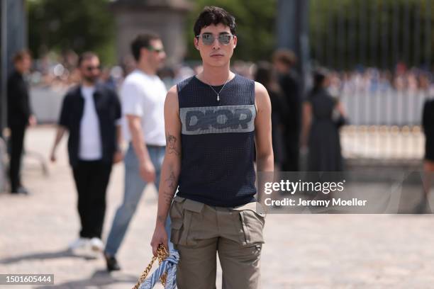 Fashion Week guest is seen wearing a Dior logo vest knit top, Dior beige cargo pants, Dior blue with gold strap Saddle bag and Dior blue sneaker...