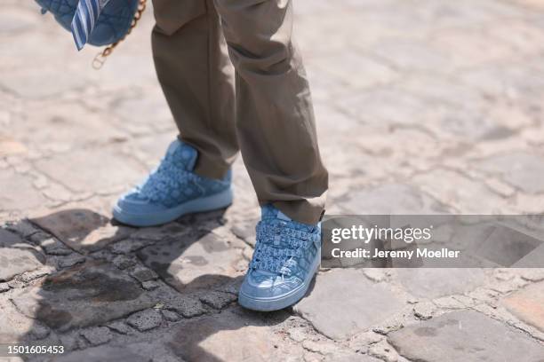 Fashion Week guest is seen wearing a Dior logo vest knit top, Dior beige cargo pants, Dior blue with gold strap Saddle bag and Dior blue sneaker...