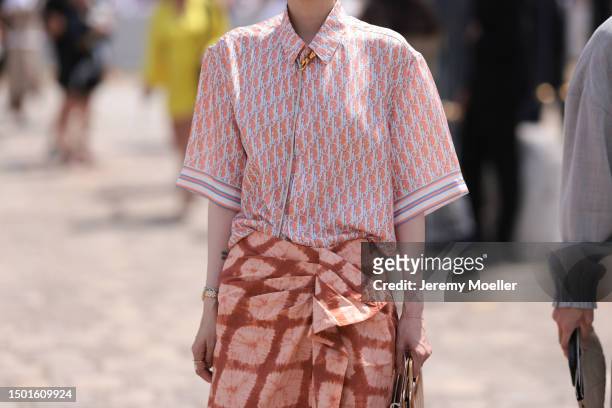 Fashion Week guest is seen wearing black shades, orange monogramm flanell shirt outside Dior Homme during the Menswear Spring/Summer 2024 as part of...