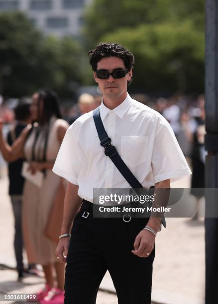 Fashion Week guest is seen wearing a white short sleeve flanell shirt, crossbody Dior Saddle bag and black pants outside Dior Homme during the...