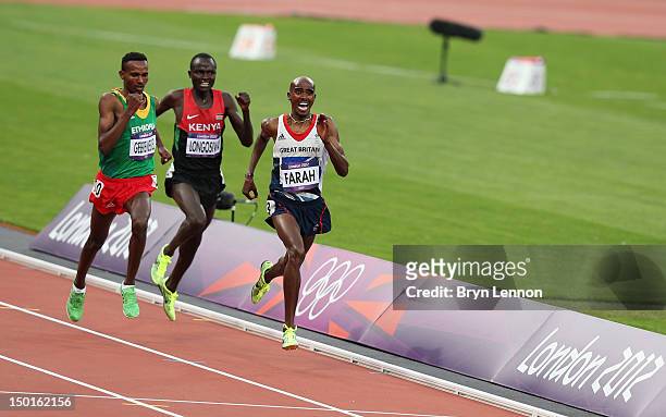 Mohamed Farah of Great Britain crosses the finish line to win gold ahead of Dejen Gebremeskel of Ethiopia and Thomas Pkemei Longosiwa of Kenya in the...