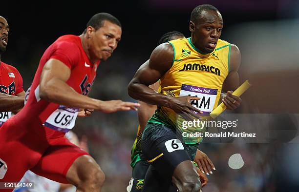 Usain Bolt of Jamaica receives the relay baton from Yohan Blake of Jamaica next to Ryan Bailey of the United States during the Men's 4 x 100m Relay...