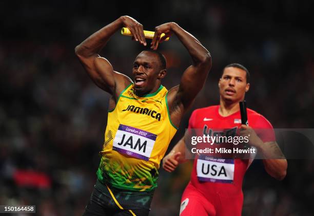 Usain Bolt of Jamaica celebrates crossing the finish line ahead of Ryan Bailey of the United States to win gold and set a new world record of 36.84...
