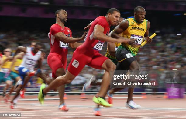 Usain Bolt of Jamaica receives the relay baton from Yohan Blake of Jamaica next to Ryan Bailey and Tyson Gay of the United States during the Men's 4...