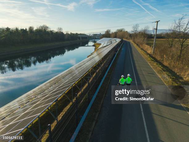 aerial view two engineers discussing operation of solar power station - väg och vattenbyggnadsingenjör bildbanksfoton och bilder