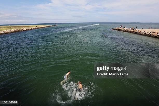 People swim beneath 'Jaws Bridge' during JawsFest: The Tribute, a festival celebrating the film Jaws, on the island of Martha’s Vineyard on August...