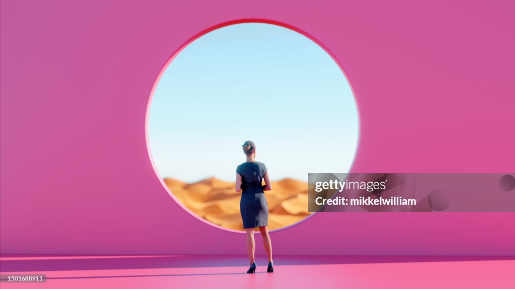 Woman Finds Peace Standing Before Pink Wall while Gazing into Desert