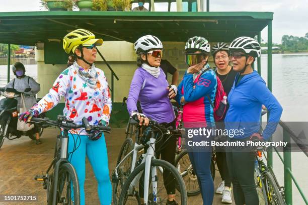 asian senior and matured cyclist on a ferry ride crossing the rajang river in sibu, sarawak, malaysia - sibu river stock pictures, royalty-free photos & images