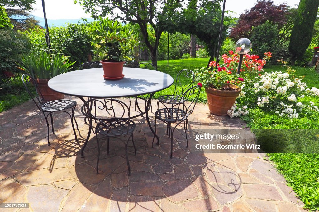 Italian patio with flower pots, table and chairs