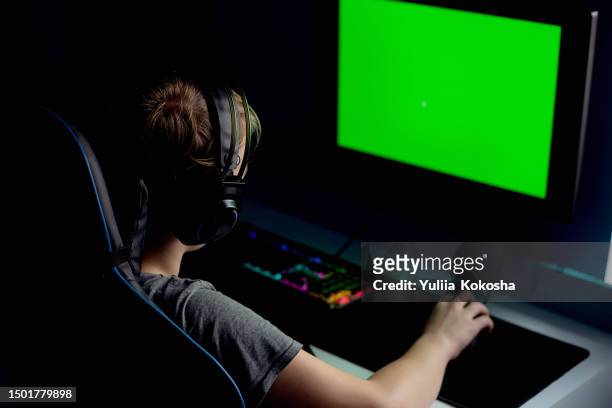 gamer playing online video game on his powerful personal computer with  neon led lights. green screen mock up. evening. - massively multiplayer online game stock pictures, royalty-free photos & images