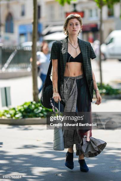 Guest wears gold earrings, a silver long chain necklace, a black V-neck bra underwear, a dark green and black checkered print pattern short sleeves...