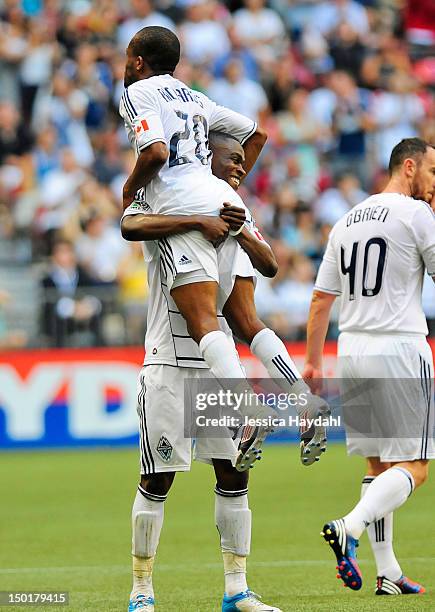 Dane Richards of the Vancouver Whitecaps gets lifted up in celebration after scoring a goal by teammate Gershon Koffie during the second half of...